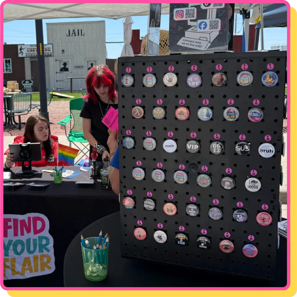Pegboard display covered in button pins next to the Find Your Flair table